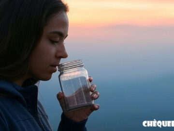 Vista de una chica respirando oxígeno de un bote de cristal.